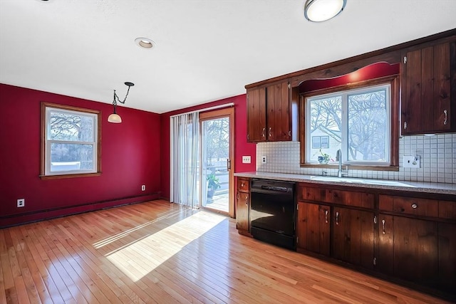 kitchen featuring baseboard heating, dishwasher, light countertops, and light wood-type flooring