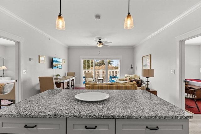 kitchen featuring hanging light fixtures, crown molding, and hardwood / wood-style flooring