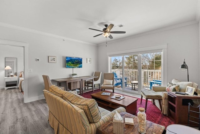 living room featuring crown molding, light hardwood / wood-style flooring, and ceiling fan