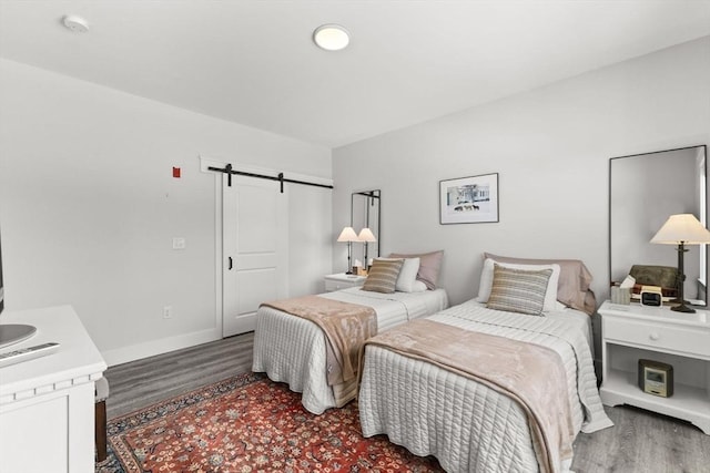 bedroom featuring dark hardwood / wood-style floors, a barn door, and a closet