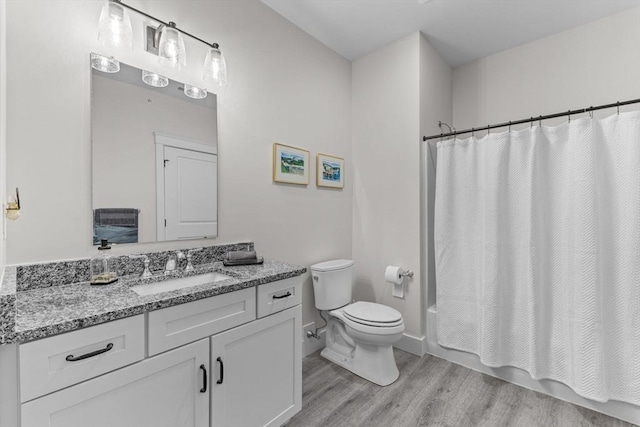 full bathroom with vanity, hardwood / wood-style floors, shower / bath combo, and toilet