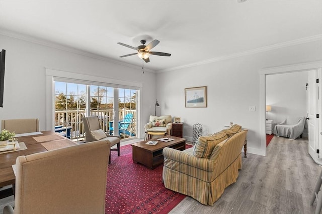 living room with ornamental molding, ceiling fan, and light hardwood / wood-style flooring