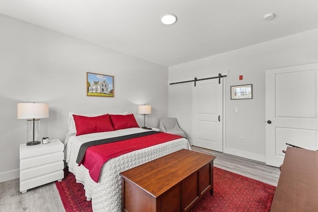 bedroom featuring hardwood / wood-style flooring and a barn door