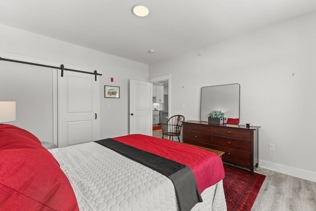 bedroom with dark hardwood / wood-style flooring and a barn door