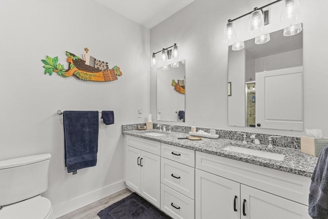 bathroom with vanity, toilet, and hardwood / wood-style floors