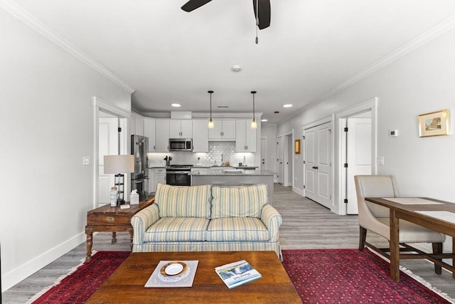 living room with hardwood / wood-style flooring, ornamental molding, and ceiling fan