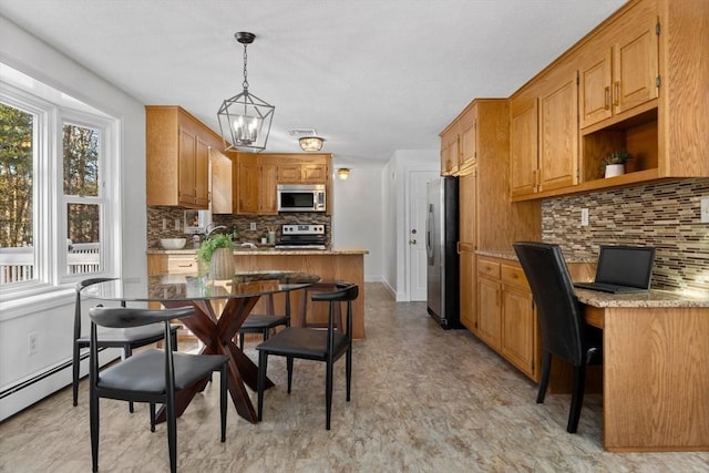 kitchen featuring decorative backsplash, stainless steel appliances, hanging light fixtures, and a breakfast bar area