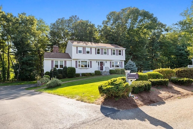 colonial inspired home with a front lawn