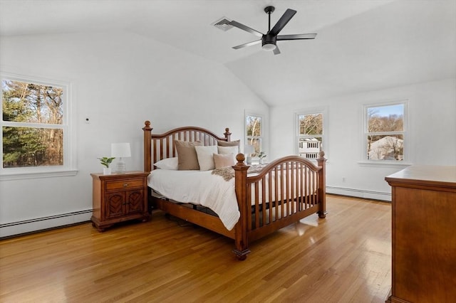 bedroom with multiple windows, light hardwood / wood-style floors, ceiling fan, and baseboard heating