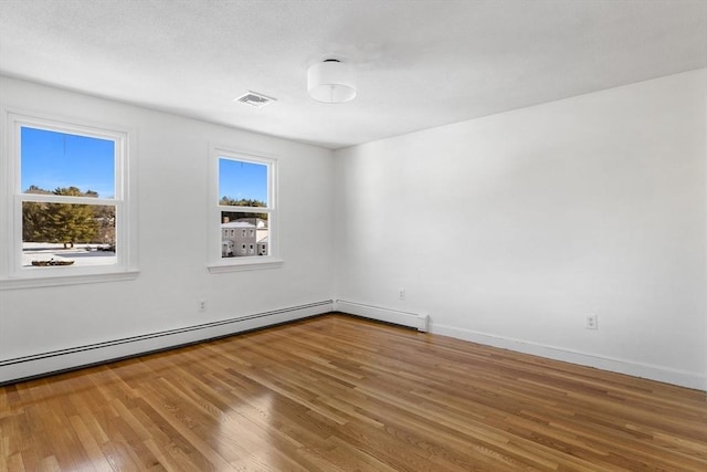 spare room featuring a baseboard radiator and wood-type flooring