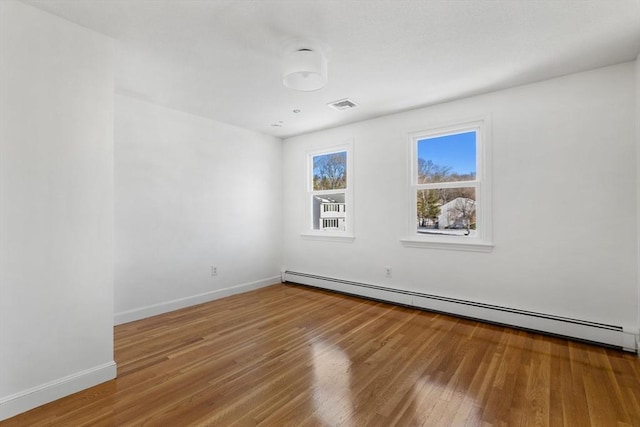 spare room with hardwood / wood-style flooring and a baseboard radiator