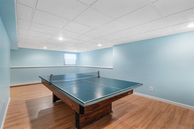 playroom featuring wood-type flooring and a baseboard heating unit