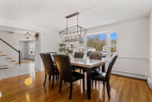 dining space featuring hardwood / wood-style flooring, a chandelier, and baseboard heating