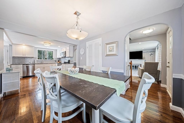 864 Front St, Weymouth, MA 02190 - dining space featuring arched walkways, dark wood-style floors, and baseboards
