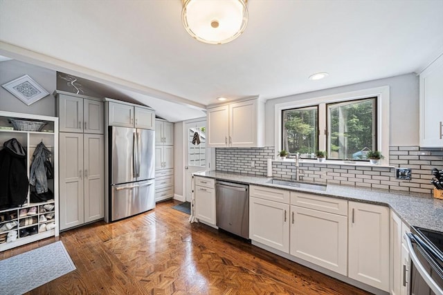 864 Front St, Weymouth, MA 02190 - kitchen with stainless steel appliances, a sink, decorative backsplash, vaulted ceiling, and light stone counters