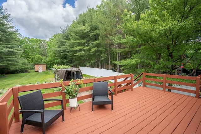 wooden deck featuring a storage shed and a yard