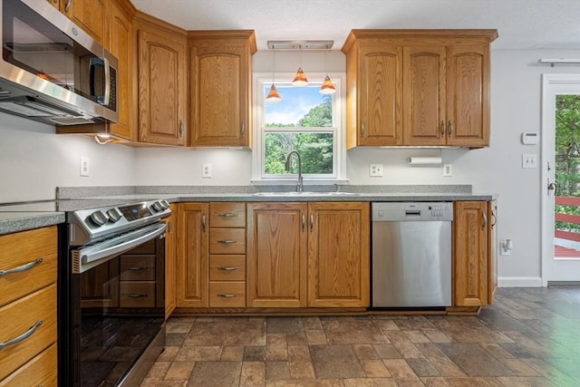 kitchen featuring appliances with stainless steel finishes, hanging light fixtures, and sink