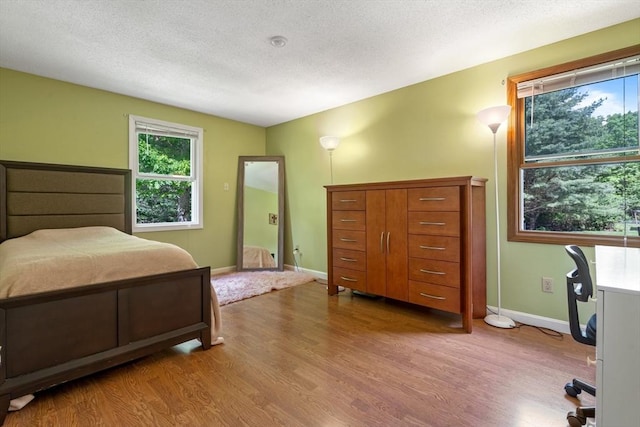 bedroom with wood-type flooring and a textured ceiling