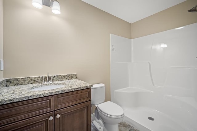 bathroom featuring tile patterned floors, toilet, a shower, and vanity