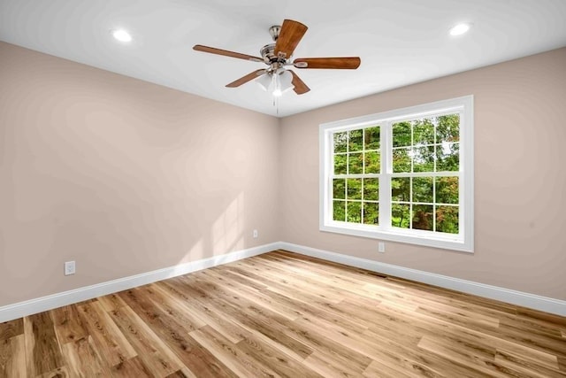 empty room with wood finished floors, ceiling fan, baseboards, and recessed lighting