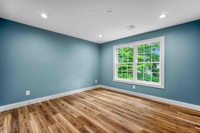 spare room featuring visible vents, baseboards, recessed lighting, and wood finished floors