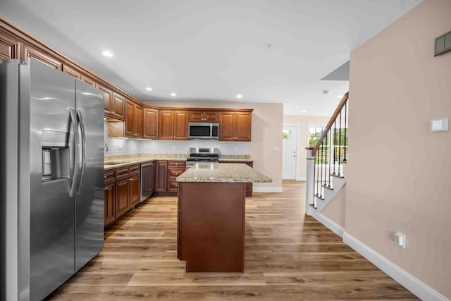 kitchen with light wood-type flooring, baseboards, recessed lighting, and stainless steel appliances