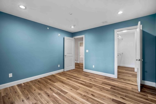 unfurnished bedroom with recessed lighting, baseboards, and wood finished floors