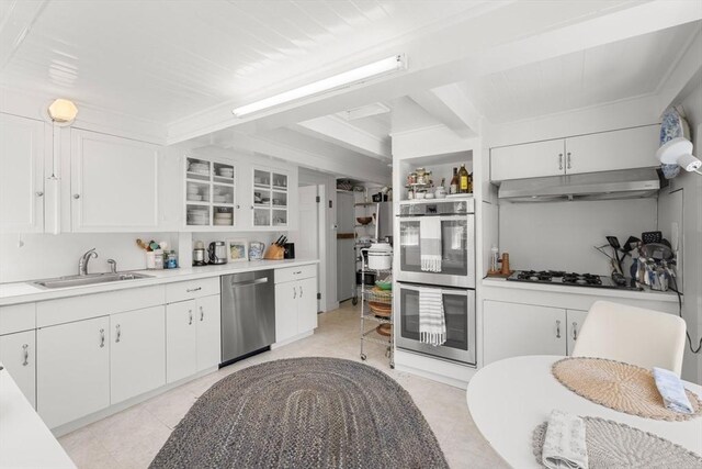 163/165 Highland St, Dedham, MA 02026 - kitchen with stainless steel appliances, under cabinet range hood, beam ceiling, and white cabinets
