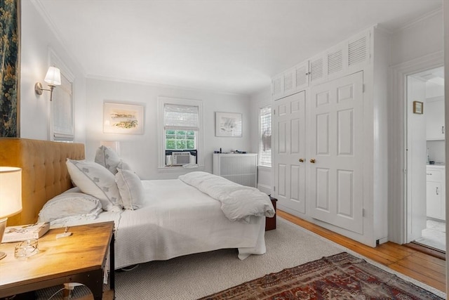 163/165 Highland St, Dedham, MA 02026 - bedroom with light wood-type flooring, cooling unit, ornamental molding, and a closet