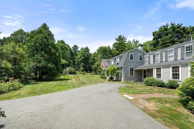163/165 Highland St, Dedham, MA 02026 - view of front facade featuring a front yard, a gambrel roof, a chimney, asphalt driveway, and roof with shingles