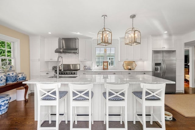 163/165 Highland St, Dedham, MA 02026 - kitchen featuring wall chimney exhaust hood, stainless steel fridge, a kitchen island with sink, tasteful backsplash, and white cabinets