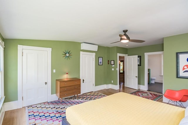 75 Lyman Rd, Northampton, MA 01060 - bedroom with a wall mounted air conditioner, baseboards, wood finished floors, and ensuite bathroom