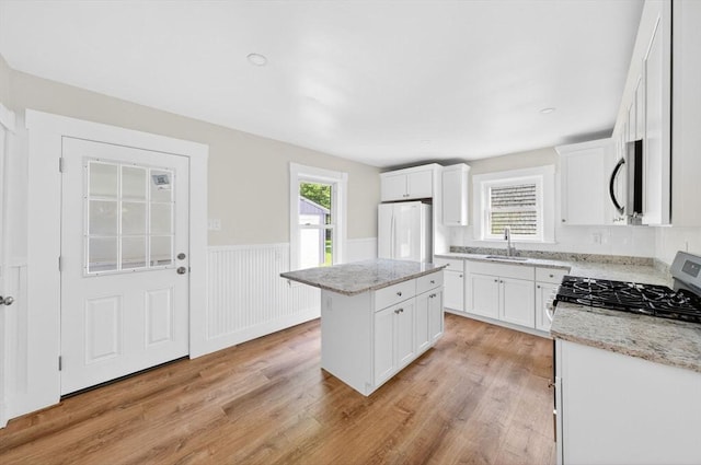 51 Ryder St, Dartmouth, MA 02747 - kitchen with stainless steel microwave, freestanding refrigerator, range, a center island, and light wood-style flooring