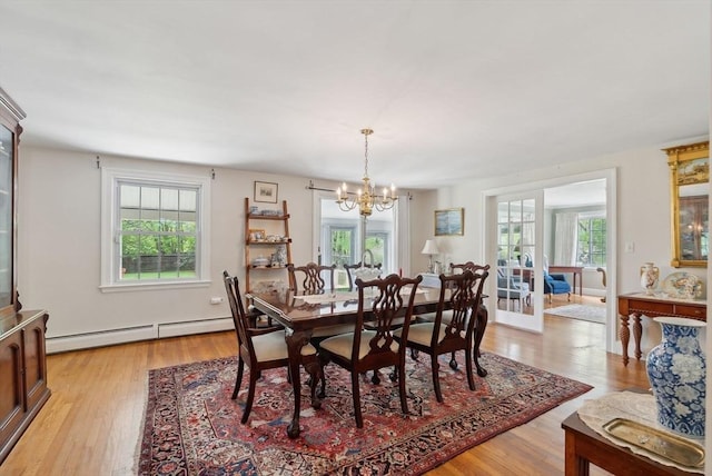 dining room with baseboard heating, a chandelier, and light wood-type flooring