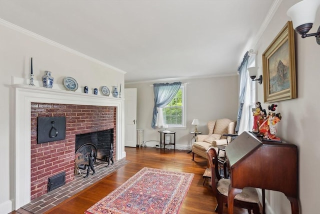 living room featuring a brick fireplace, wood finished floors, crown molding, baseboards, and radiator