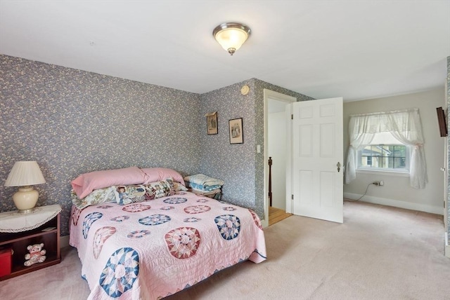 carpeted bedroom featuring wallpapered walls and baseboards