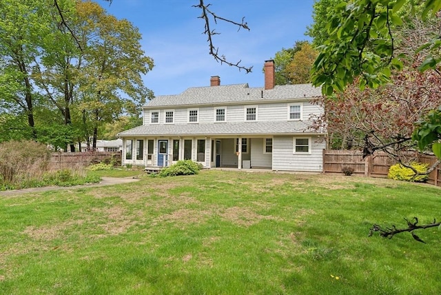back of property with a chimney and a shingled roof