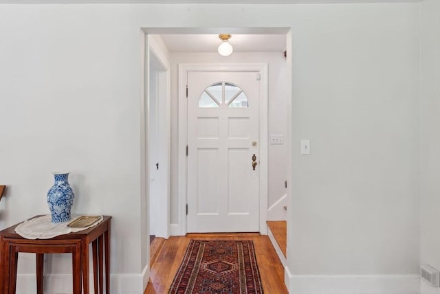 entryway with light wood finished floors and baseboards