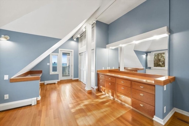 bonus room featuring a wealth of natural light, visible vents, light wood-style floors, a baseboard heating unit, and baseboards