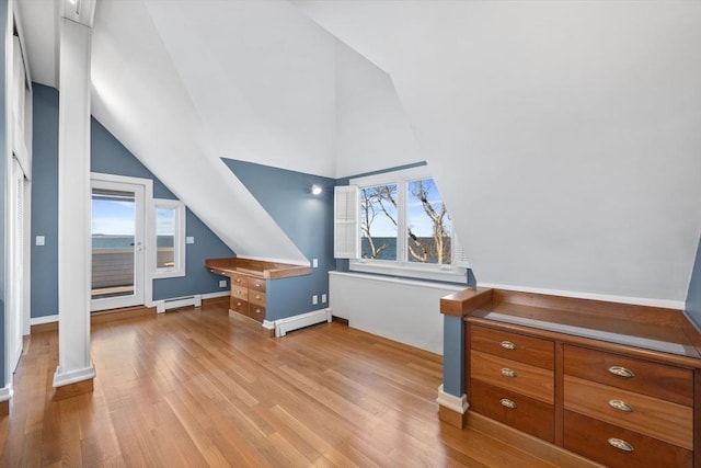 bonus room featuring vaulted ceiling, baseboard heating, light wood-style flooring, and ornate columns