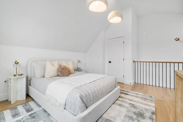 bedroom featuring hardwood / wood-style floors and vaulted ceiling