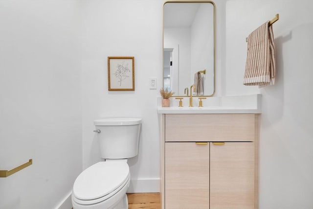 bathroom featuring vanity, toilet, and hardwood / wood-style floors