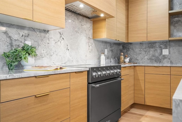 kitchen featuring light hardwood / wood-style flooring, wall chimney range hood, decorative backsplash, and electric stove