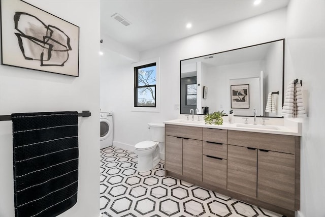 bathroom featuring vanity, washer / dryer, and toilet