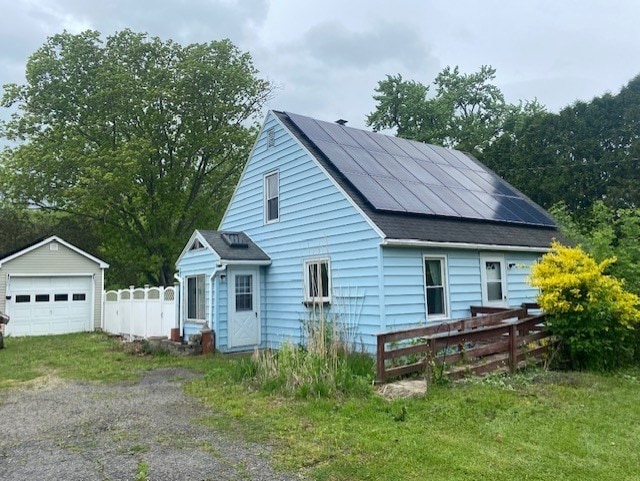 exterior space with a garage, an outdoor structure, and solar panels