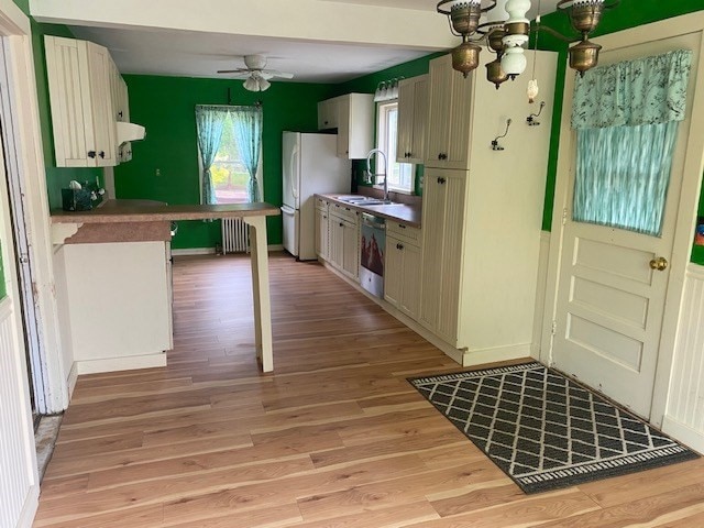 kitchen featuring light hardwood / wood-style floors, a kitchen breakfast bar, ceiling fan, sink, and radiator heating unit