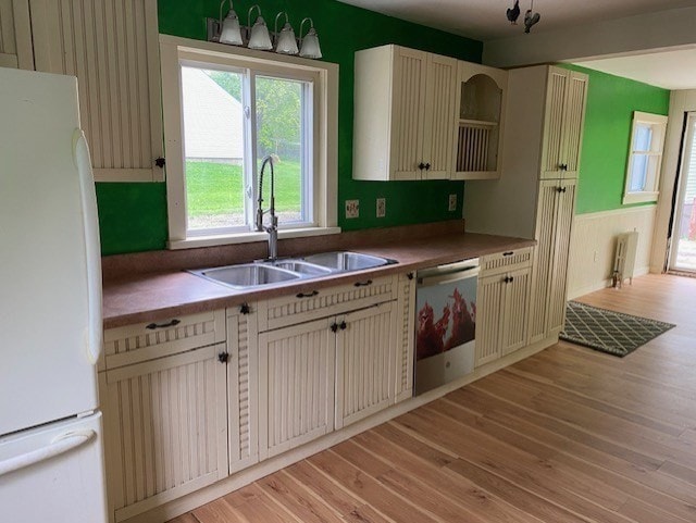 kitchen with dishwasher, sink, white fridge, and light wood-type flooring