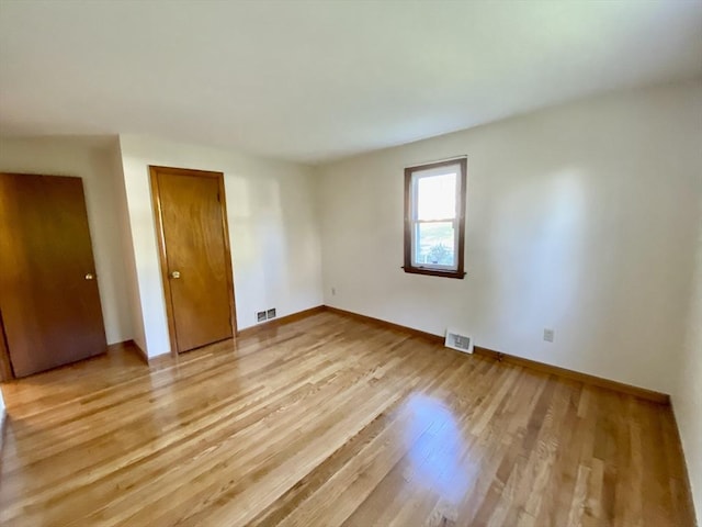 unfurnished room featuring baseboards and light wood-type flooring