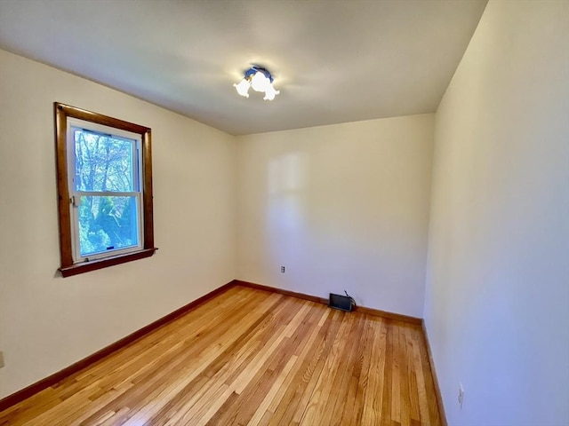empty room featuring light wood finished floors and baseboards