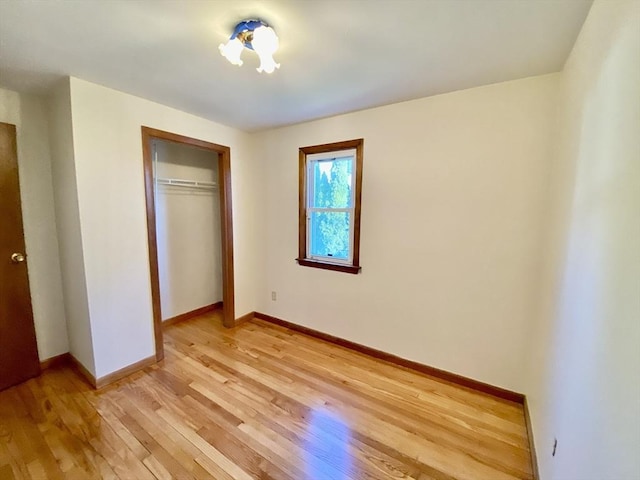 unfurnished bedroom with light wood-style floors, baseboards, and a closet